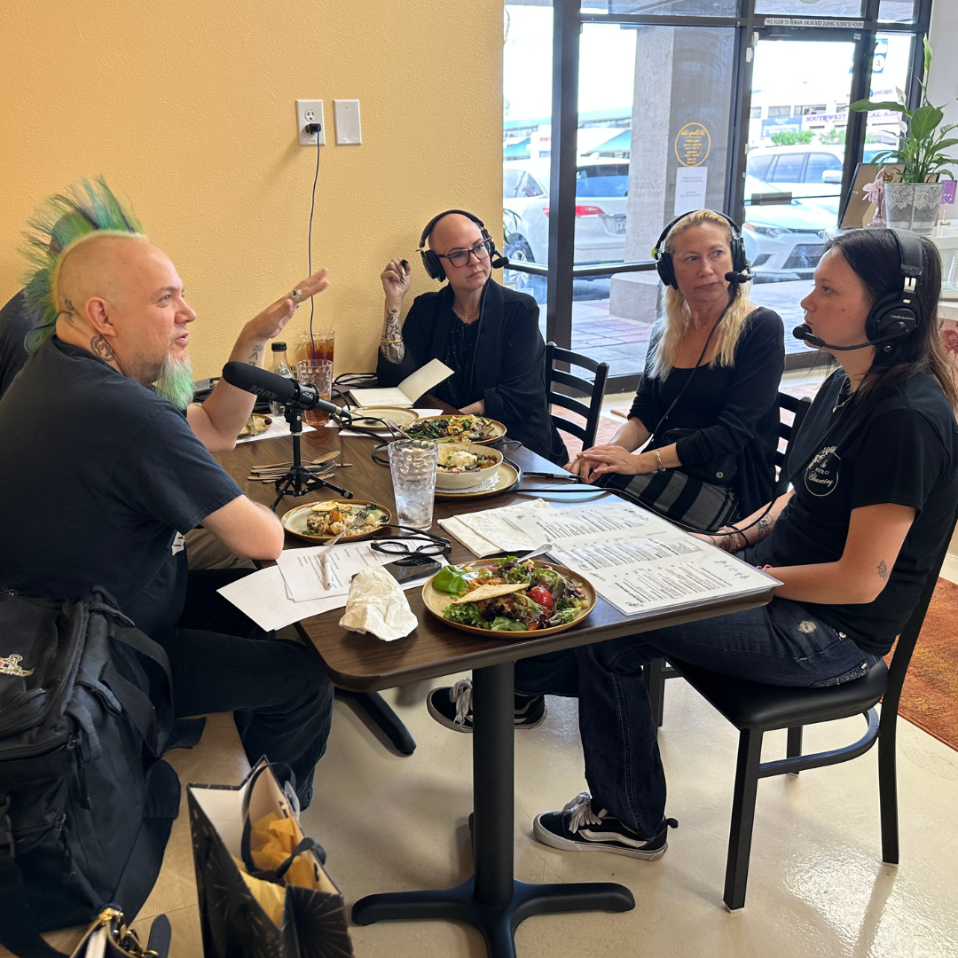 People sit around a restaurant table recording a podcast interview.