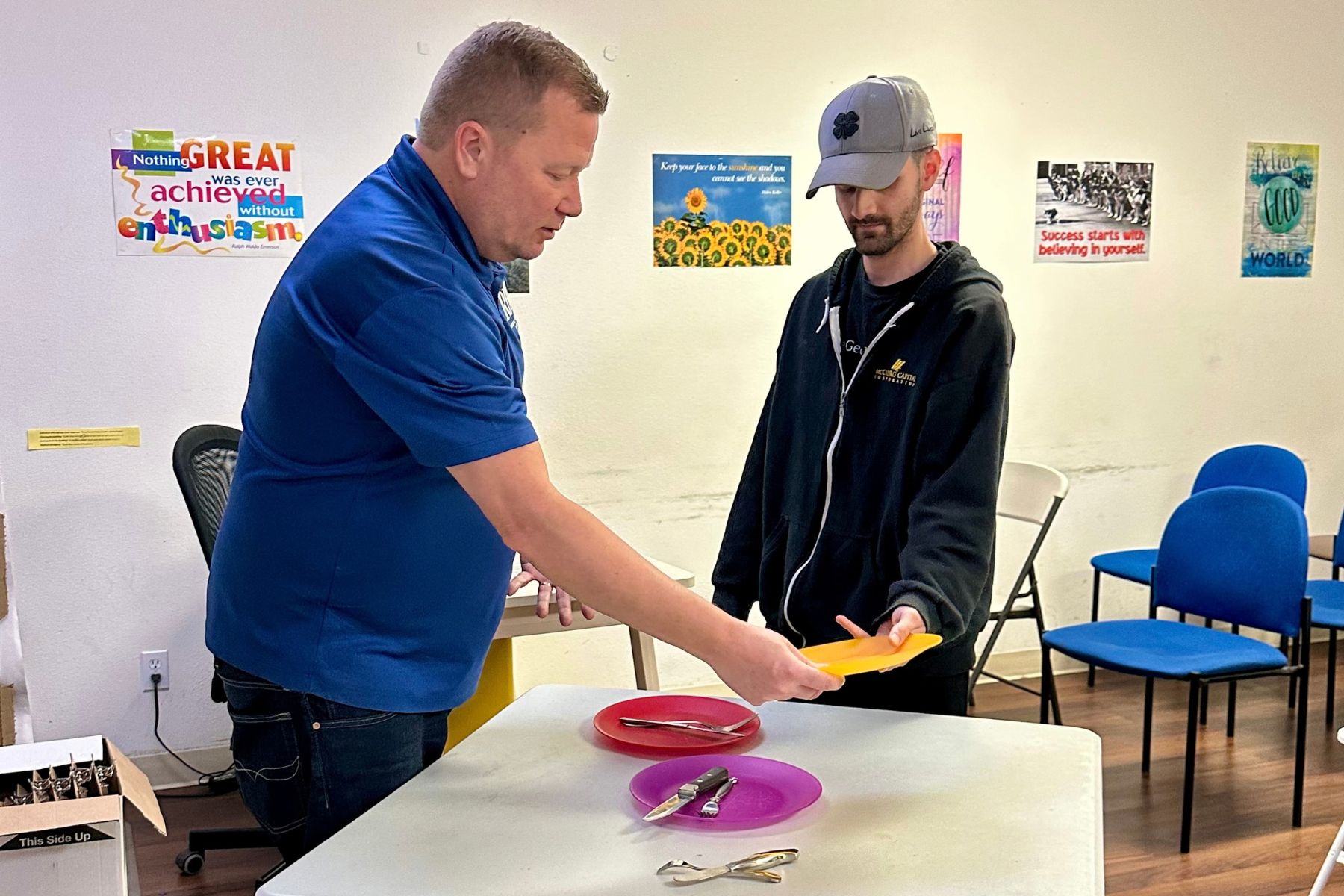 Mark Steele teaches a student how to properly clear dishes from a table.